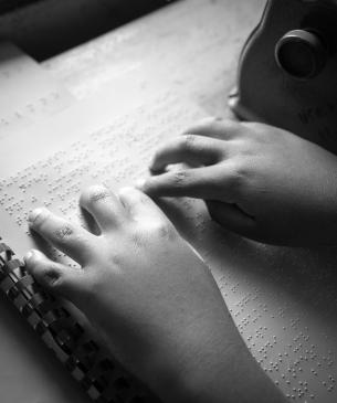 child reading braille