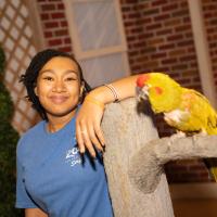 Previous RISE Scholarship recipient, Adanna Davis, stands next to bird
