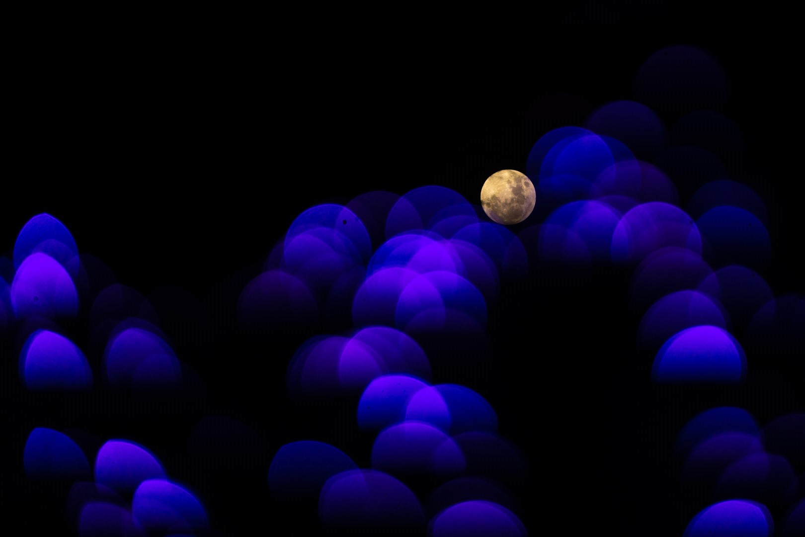 blue holiday lights and full moon