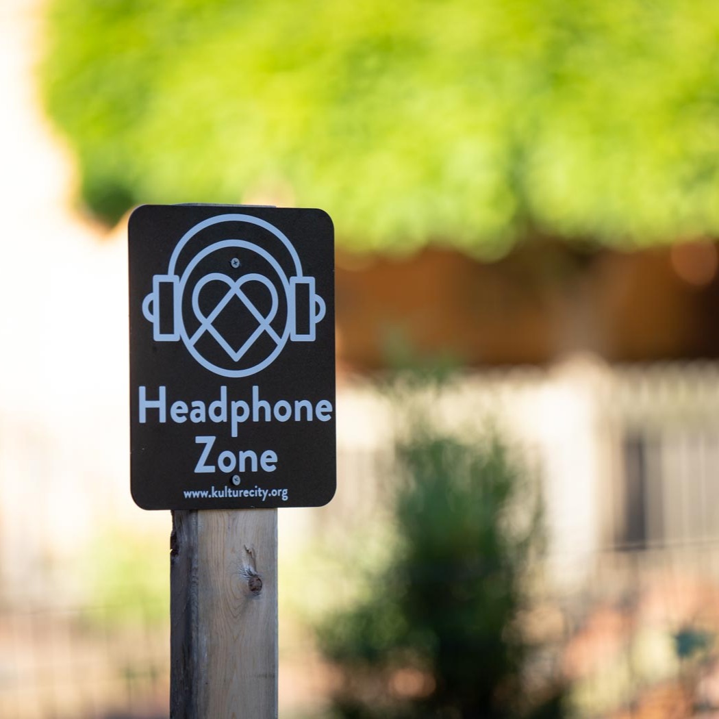 Headphone Zone sign with blurred outdoor background