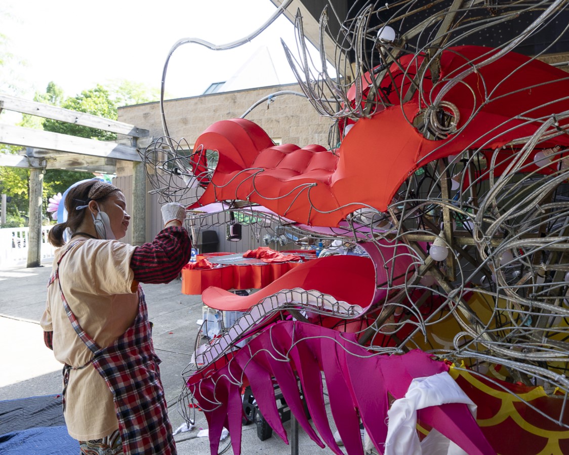 woman assembling dragon lantern