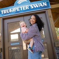 family posing in front of zoo sign