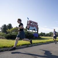 5k participant running past Zoo sign