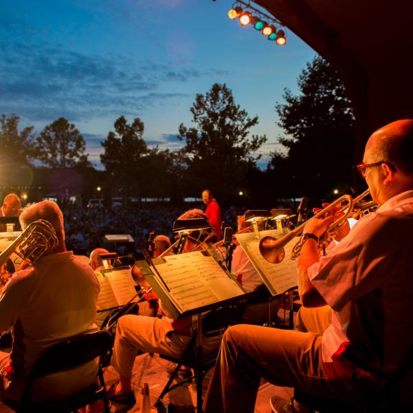 musicians on stage with evening sky